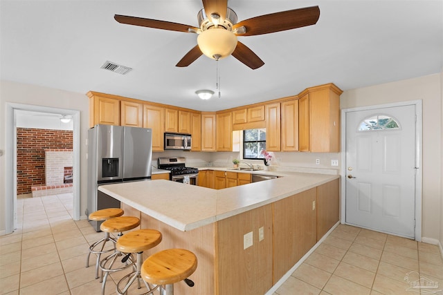 3332 Laurel Dr, Gulf Breeze, FL 32563 - kitchen featuring stainless steel appliances, light tile patterned floors, light countertops, and a peninsula