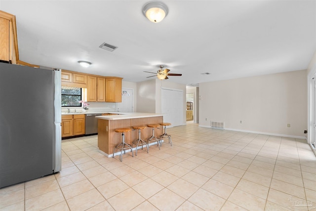 3332 Laurel Dr, Gulf Breeze, FL 32563 - kitchen featuring appliances with stainless steel finishes, light countertops, a kitchen bar, a ceiling fan, and a sink
