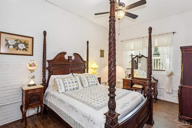 bedroom featuring dark wood-type flooring, ceiling fan, and brick wall