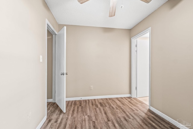 spare room with ceiling fan, light wood-type flooring, and a textured ceiling