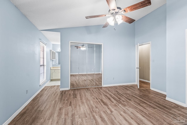 unfurnished bedroom with ceiling fan, light hardwood / wood-style flooring, connected bathroom, a closet, and lofted ceiling