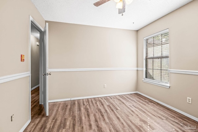 spare room with hardwood / wood-style floors, a textured ceiling, and ceiling fan