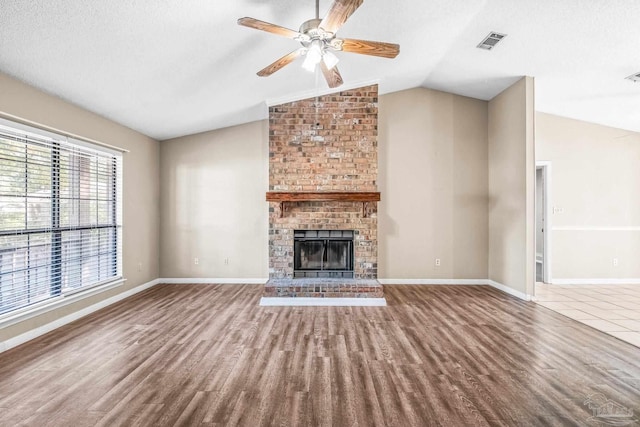 unfurnished living room with hardwood / wood-style flooring, plenty of natural light, and lofted ceiling