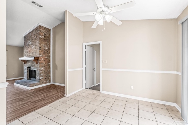 unfurnished living room featuring ceiling fan, a fireplace, light hardwood / wood-style floors, and lofted ceiling