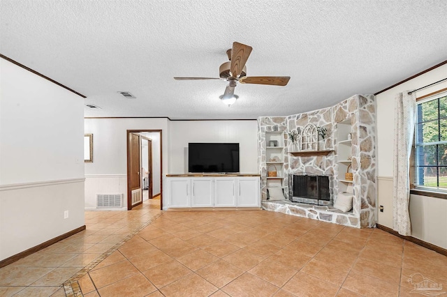 unfurnished living room with light tile patterned flooring, a fireplace, ornamental molding, ceiling fan, and a textured ceiling