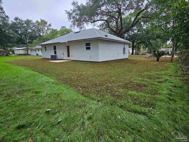 rear view of property with central AC unit, a patio, and a lawn