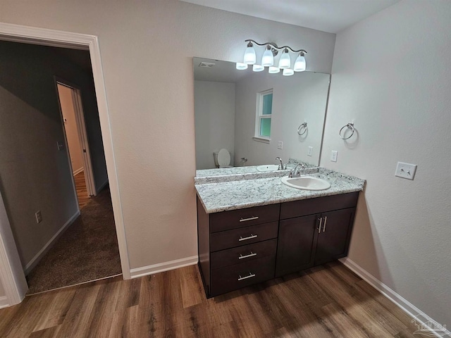 bathroom featuring wood-type flooring, toilet, and vanity