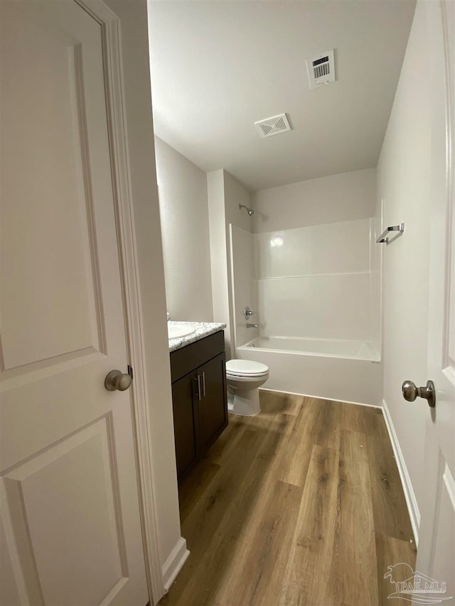 full bathroom featuring wood-type flooring, vanity, toilet, and shower / washtub combination