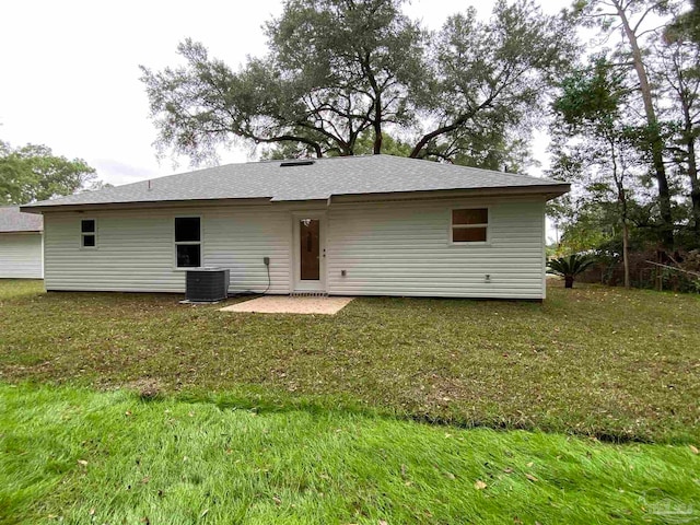 rear view of property featuring central AC unit, a patio area, and a yard