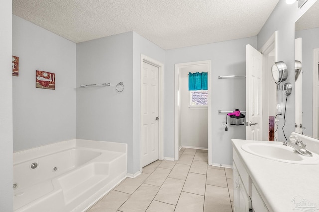 bathroom featuring tile patterned flooring, vanity, a textured ceiling, and a tub to relax in