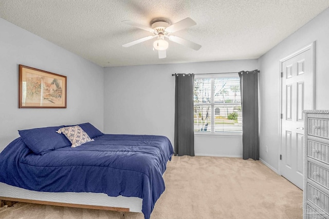 carpeted bedroom featuring ceiling fan and a textured ceiling