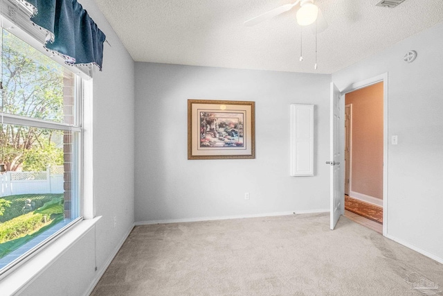 carpeted empty room with a textured ceiling and ceiling fan