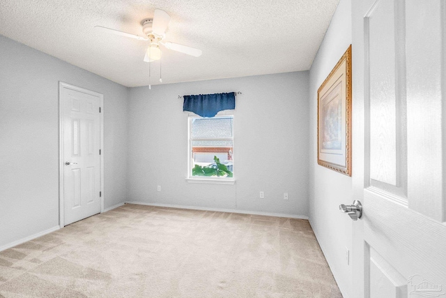 carpeted empty room with ceiling fan and a textured ceiling