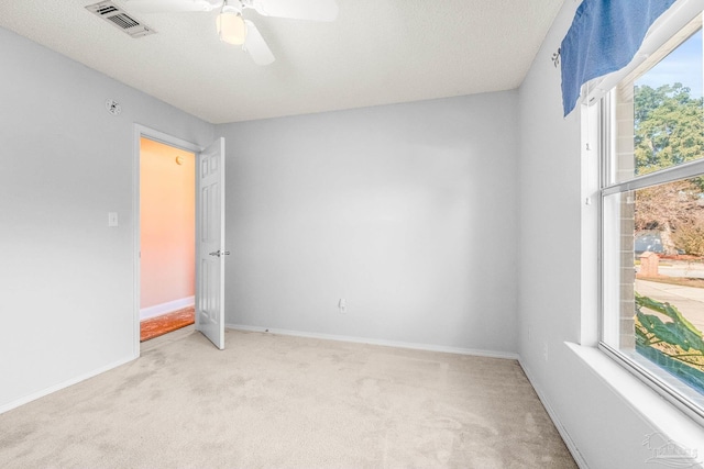 carpeted empty room with a textured ceiling and ceiling fan