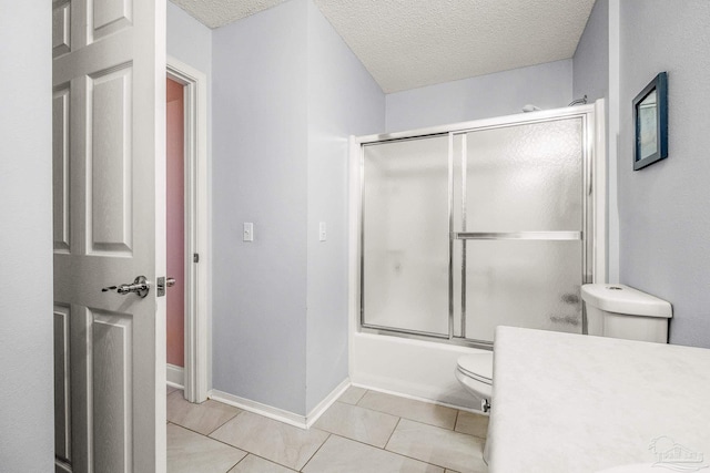 full bathroom with vanity, bath / shower combo with glass door, tile patterned flooring, toilet, and a textured ceiling