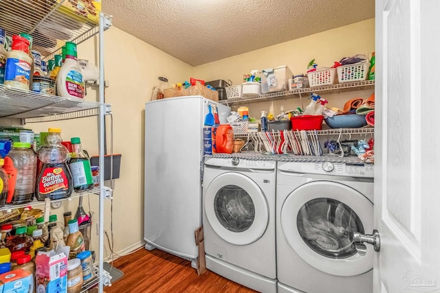 clothes washing area with a textured ceiling, separate washer and dryer, and dark wood-type flooring