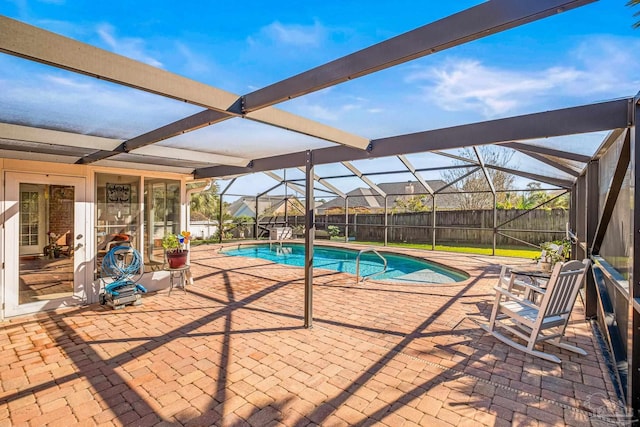 view of swimming pool with glass enclosure and a patio area