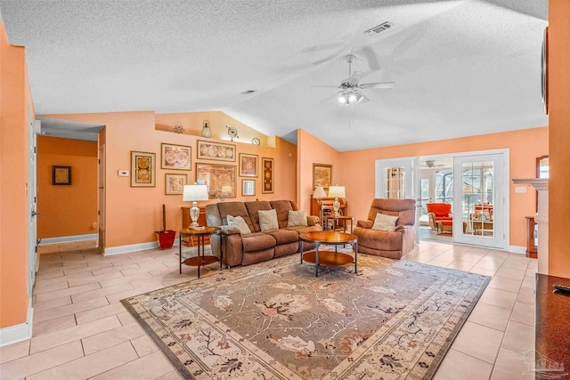 living room with light tile patterned floors, a textured ceiling, ceiling fan, and lofted ceiling