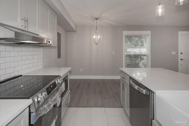 kitchen featuring white cabinets, appliances with stainless steel finishes, and decorative light fixtures