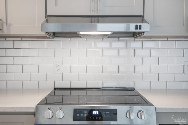 kitchen featuring range and backsplash