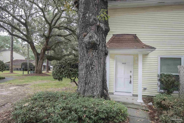 view of exterior entry featuring a lawn