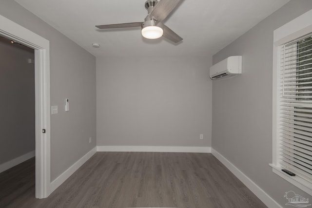 unfurnished bedroom featuring a spacious closet, hardwood / wood-style flooring, an AC wall unit, and ceiling fan