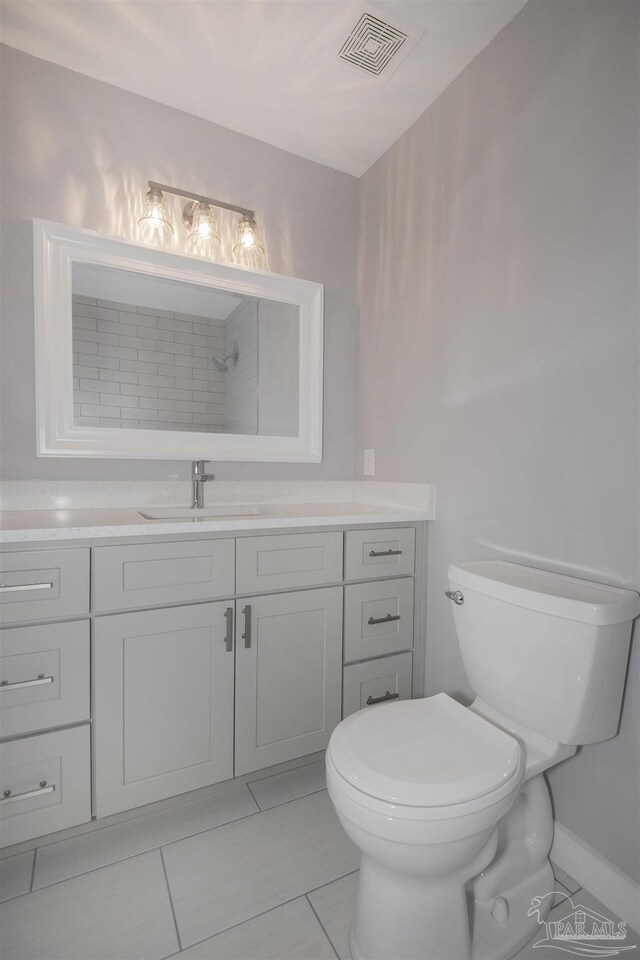 bathroom featuring tile patterned flooring, vanity, and toilet