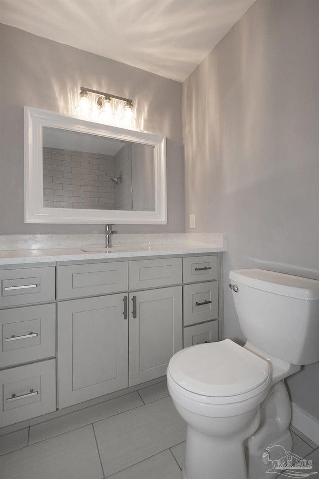 bathroom with tile patterned flooring, vanity, and toilet