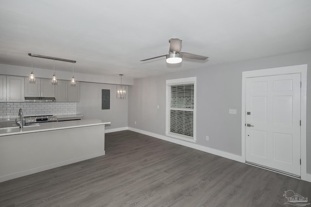 kitchen featuring gray cabinetry, ceiling fan, hanging light fixtures, electric panel, and decorative backsplash