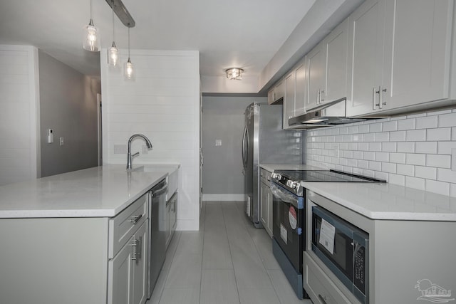 kitchen featuring sink, hanging light fixtures, decorative backsplash, light tile patterned flooring, and appliances with stainless steel finishes