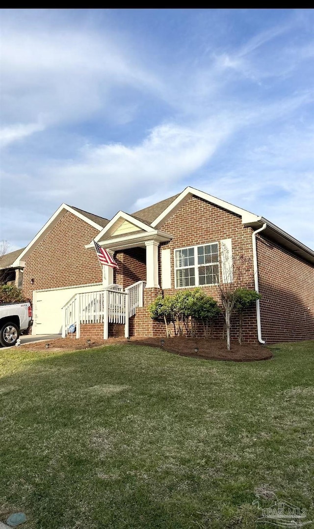 single story home featuring a front yard, a garage, and brick siding