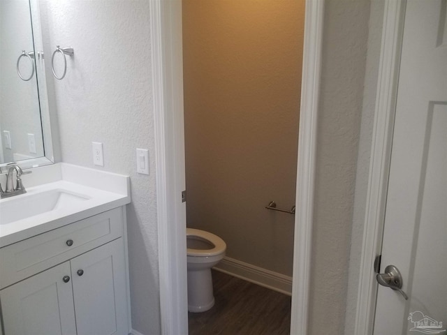 bathroom featuring wood-type flooring, vanity, and toilet