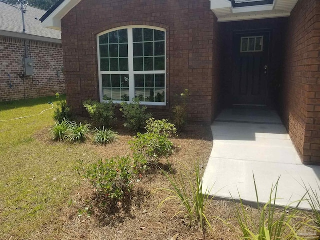 view of exterior entry with a yard