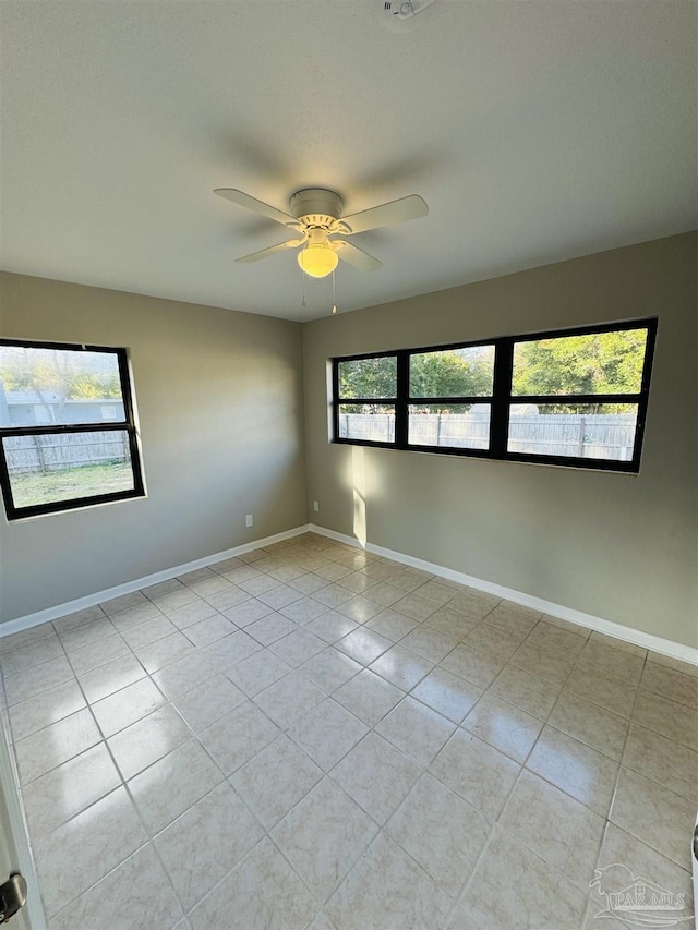 tiled spare room featuring ceiling fan