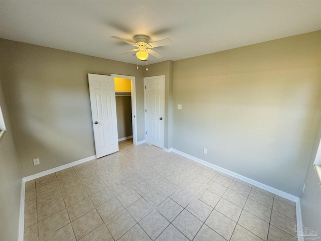 tiled empty room featuring ceiling fan