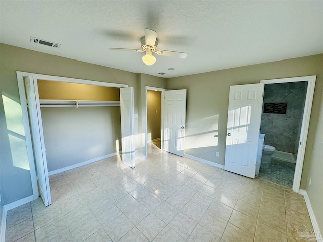 unfurnished bedroom featuring connected bathroom, ceiling fan, a closet, and a textured ceiling