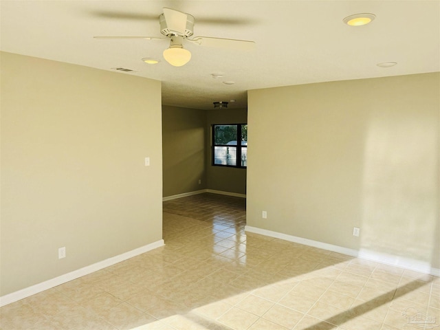 tiled spare room with ceiling fan