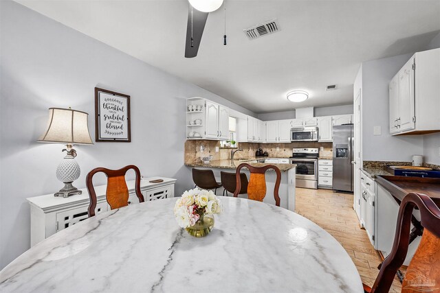 dining space featuring light hardwood / wood-style floors, ceiling fan, and sink