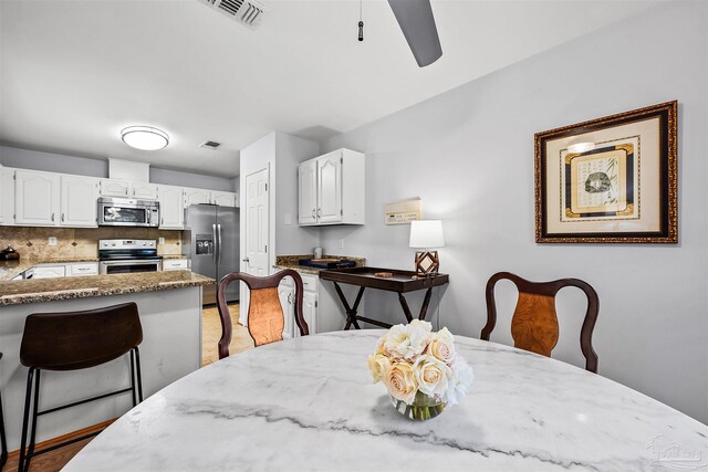 dining area with ceiling fan and light wood-type flooring