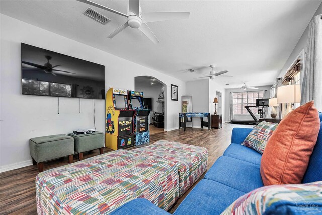 living room featuring ceiling fan and dark wood-type flooring