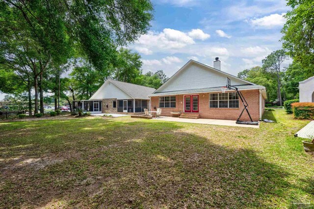 back of property featuring a patio area and a yard