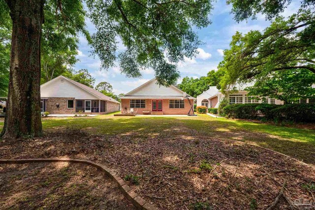 rear view of property featuring a yard