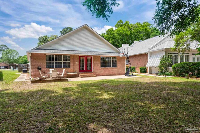 back of property featuring a lawn, french doors, and a patio area