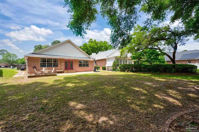 rear view of house featuring a lawn and a patio area