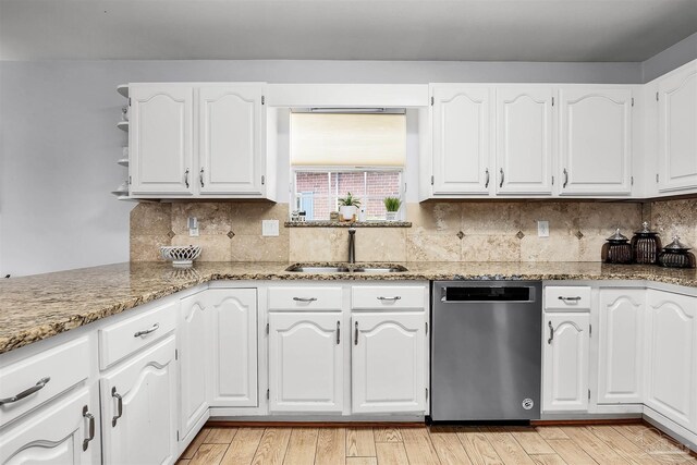 kitchen with light hardwood / wood-style floors, stainless steel dishwasher, white cabinetry, and sink