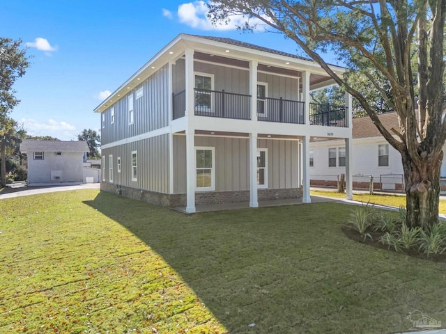 back of house featuring a balcony and a lawn