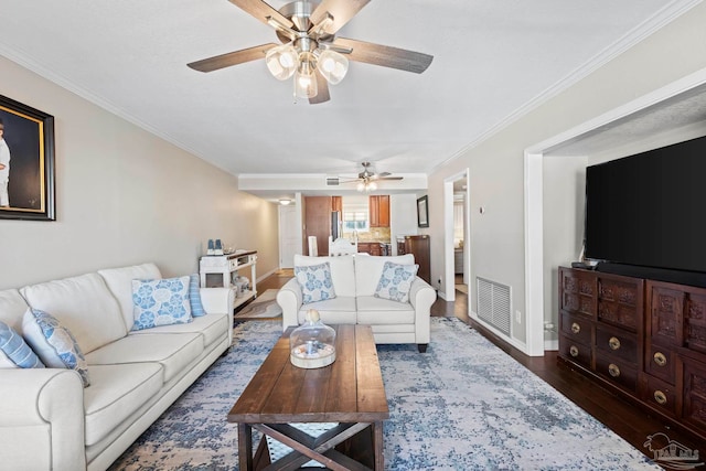 living room with ceiling fan, ornamental molding, and dark hardwood / wood-style floors