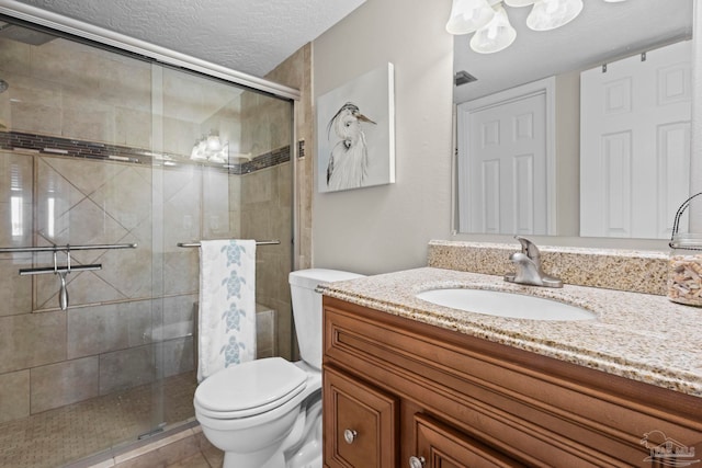 bathroom with vanity, an enclosed shower, a textured ceiling, and toilet