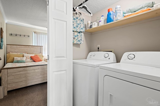 clothes washing area with dark colored carpet, washing machine and clothes dryer, and a textured ceiling