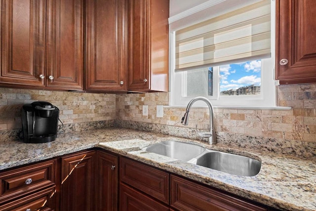 kitchen with tasteful backsplash, sink, and light stone counters